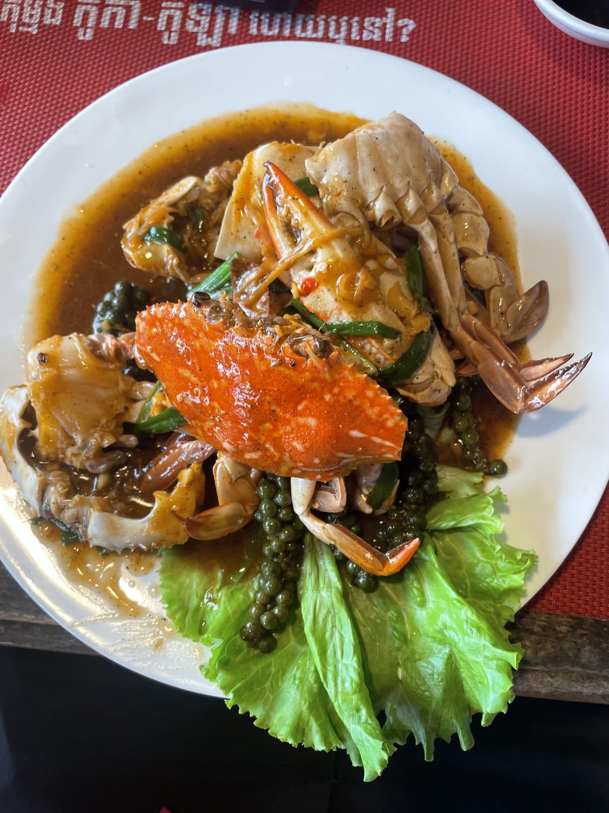 A whole crab in Kampot pepper sauce, served on a bed of lettuce