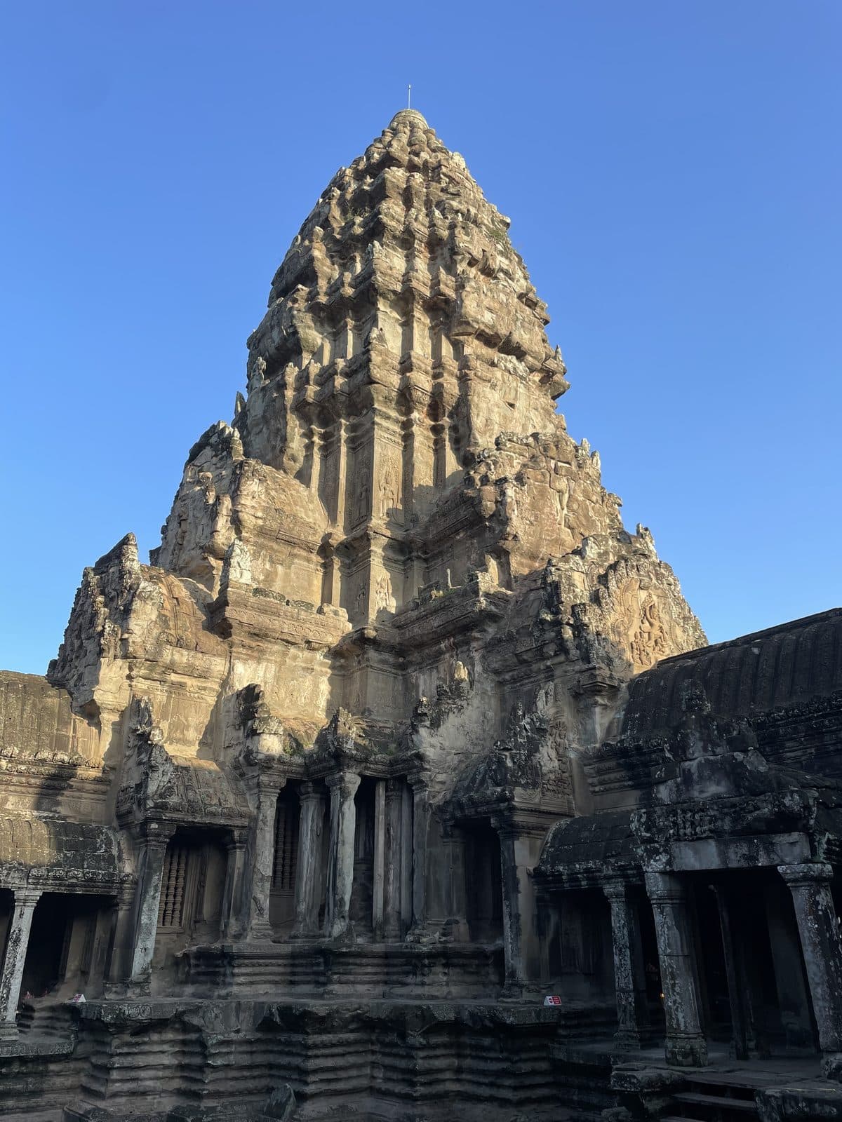 The central tower of Angkor Wat rising against a clear blue sky